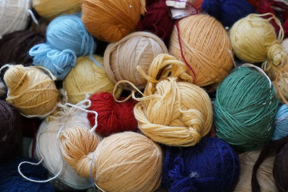A pile of yarn balls in varied colors and thicknesses